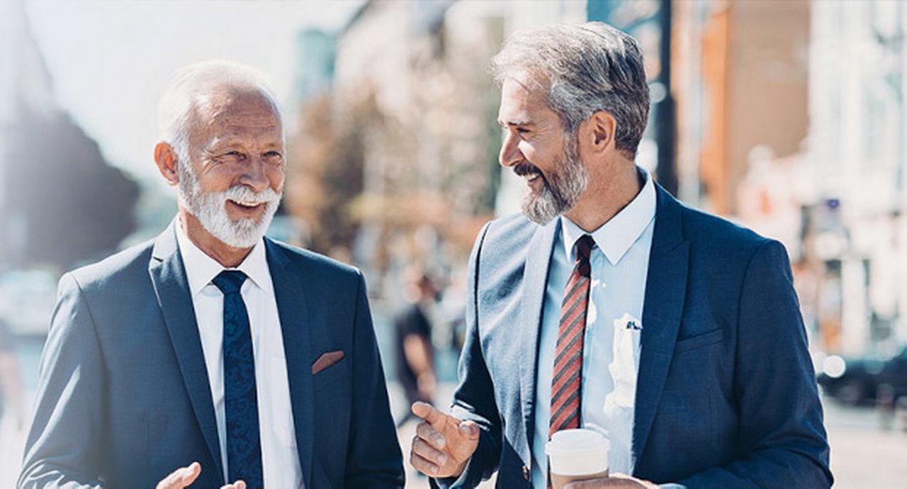 Two distinguished businessmen discussing while walking